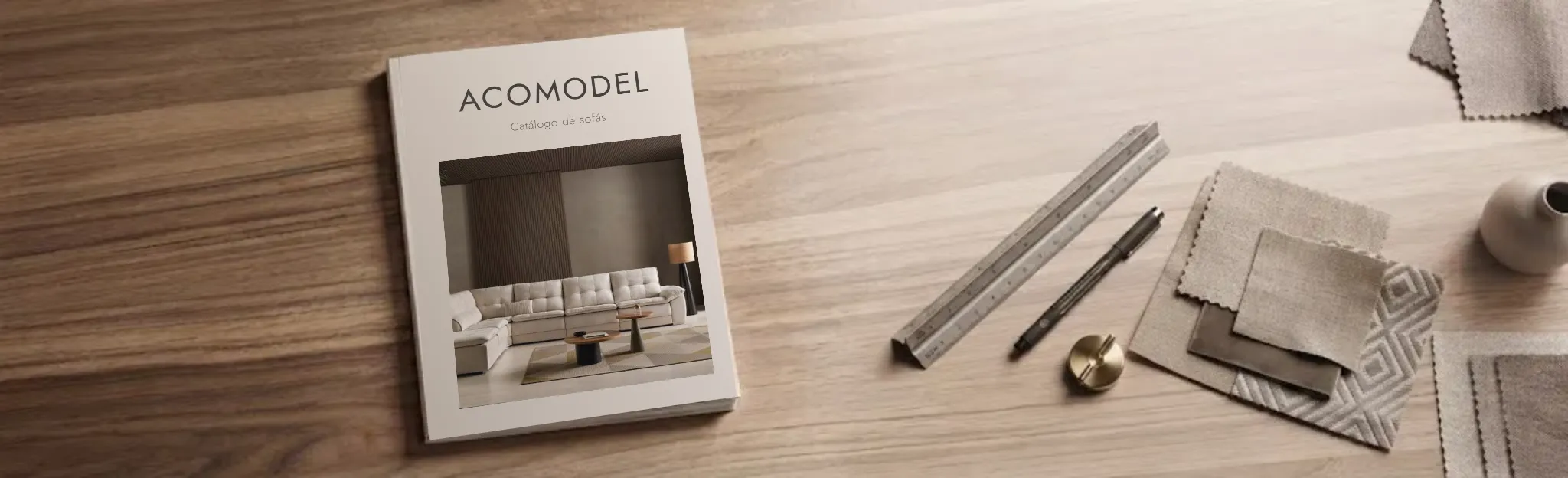 Catálogo de sofás Acomodel sobre mesa de madera con muestras de tejido para profesionales - Valencia